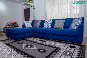 A carpet next to a 5 seater L-sectional sofa.
